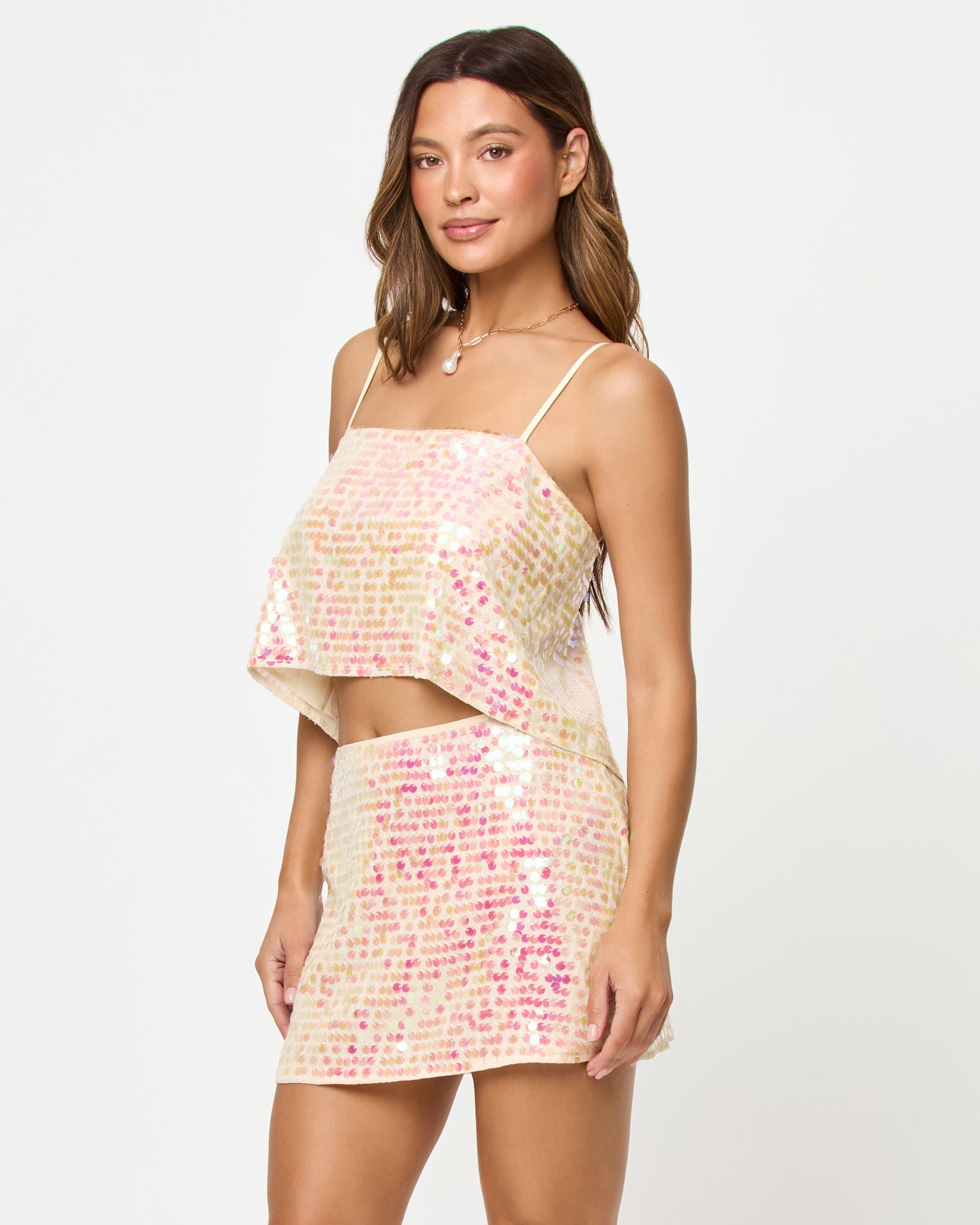 Woman wearing a sequined two-piece outfit on a white background