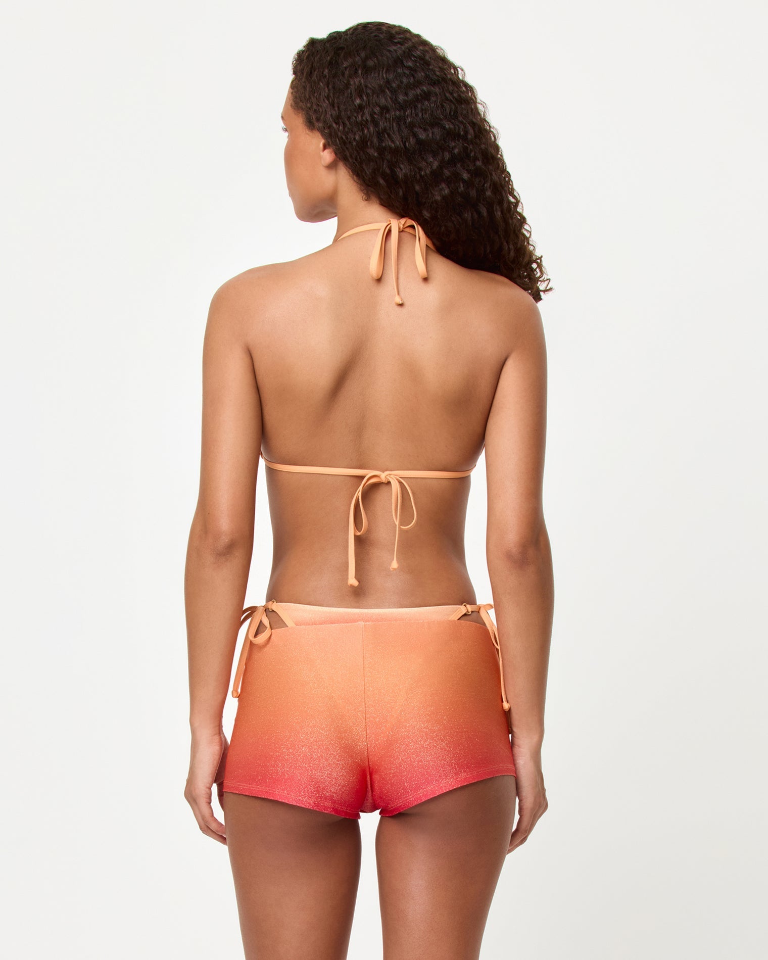 Woman wearing a two-piece swimsuit with a gradient design on a white background