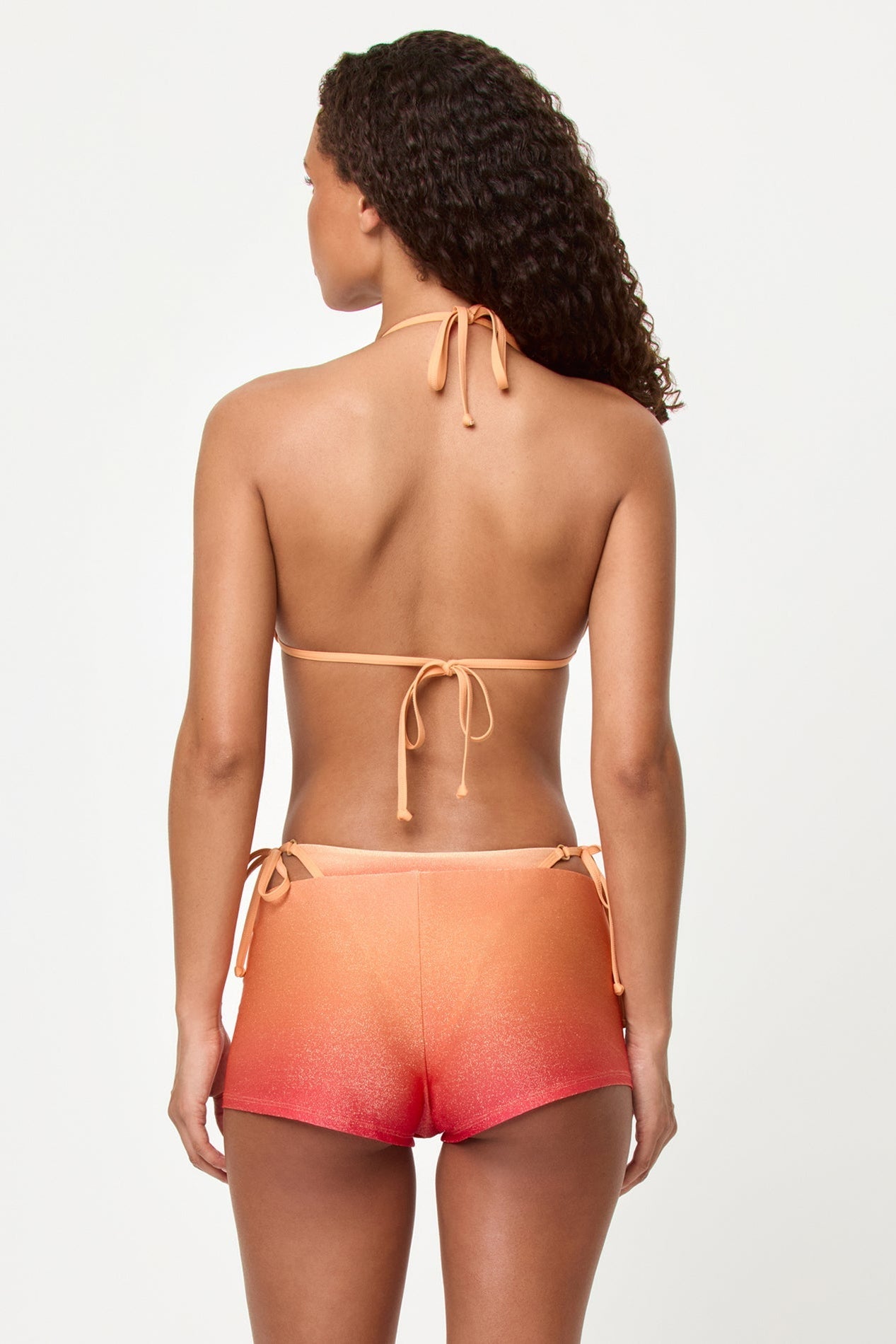 Woman wearing a two-piece swimsuit with a gradient design on a white background