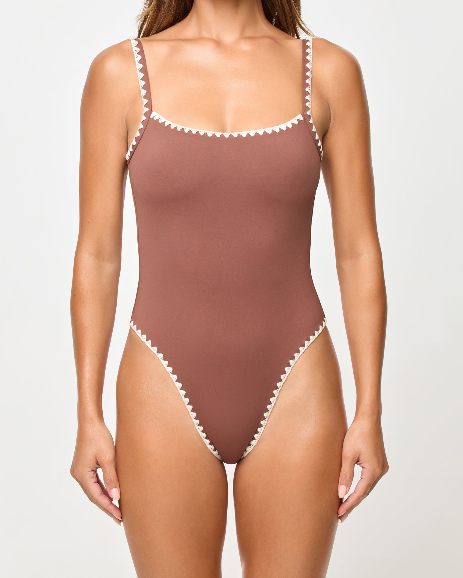 Brown one-piece swimsuit with white trim on a plain background